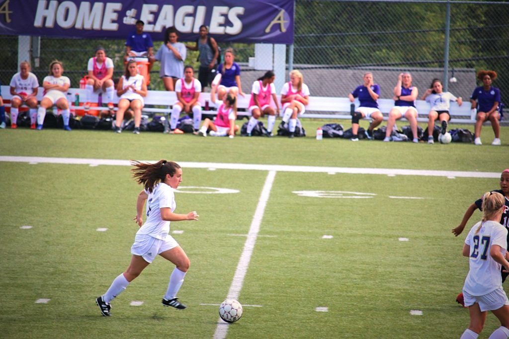Avila female soccer player dribbling at mid-field