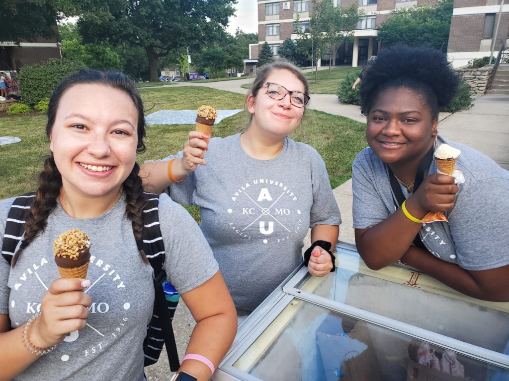 三名阿维拉学生拿着冰淇淋甜筒在校园里摆姿势