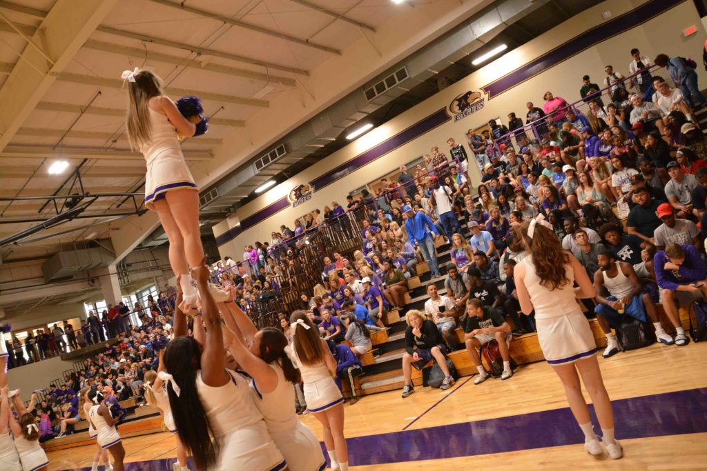 Cheerleaders performing a stunt inside the Mabee Fieldhouse in front of a packed house
