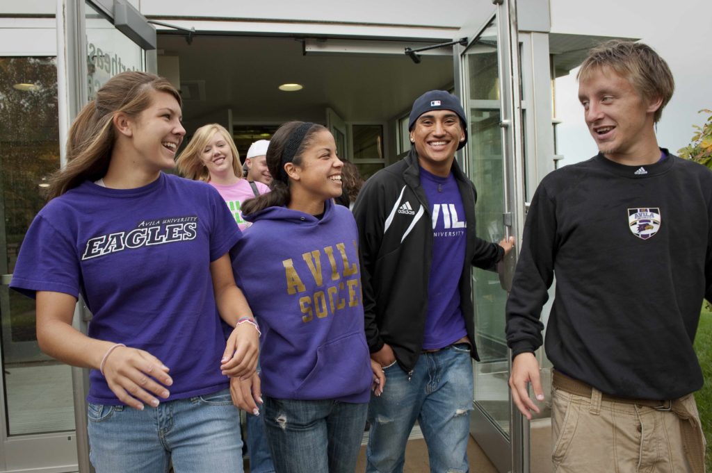 Group of four students exiting the doors of Mabee Fieldhouse