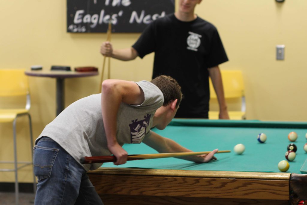 Two students playing pool in the Eagles Nest