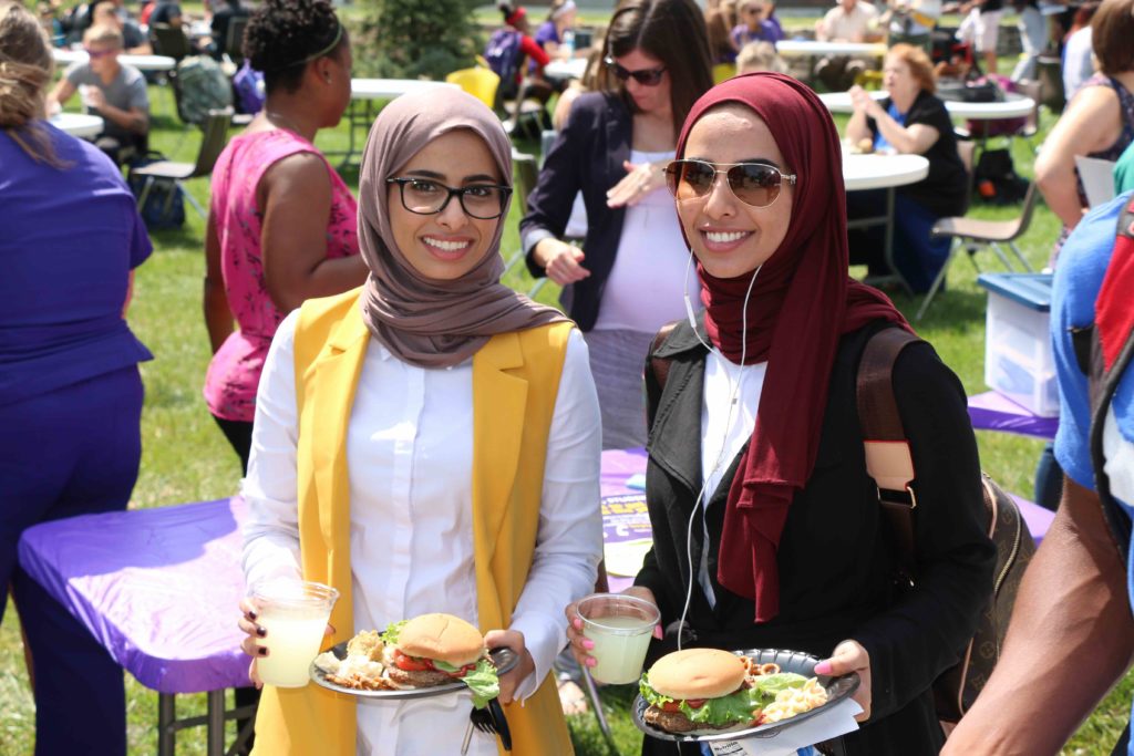 Two students enjoying the free burgers at a campus carnival