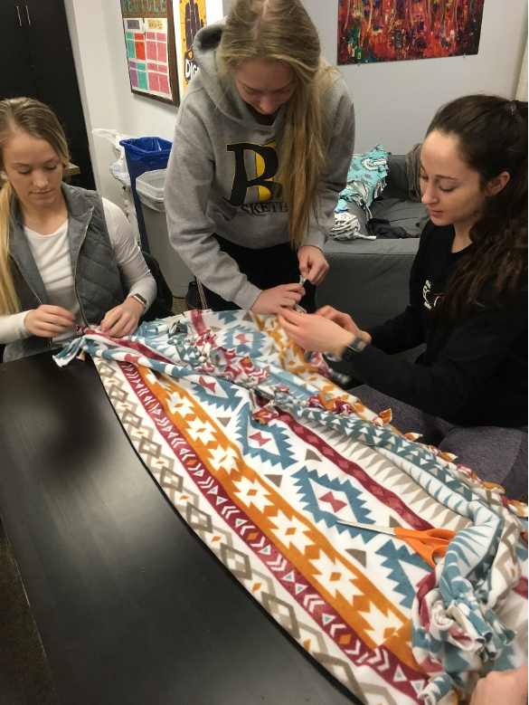Three students Making blankets for kids at Children’s Mercy Hospital
