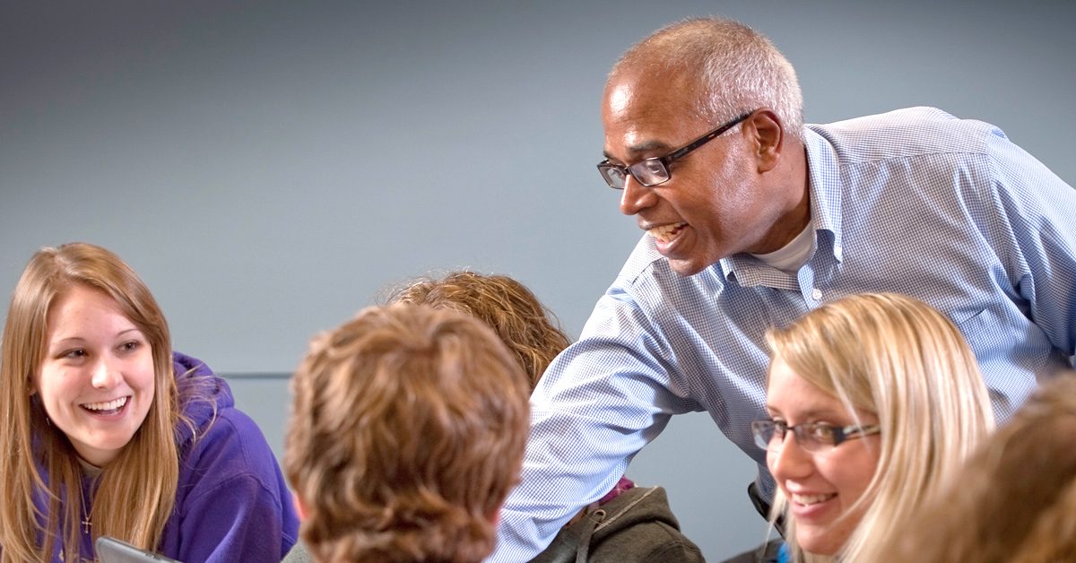 Avila Professor Daniel George in class with a group of students