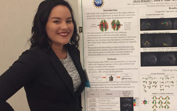 Alexis Delgado standing in front of research poster