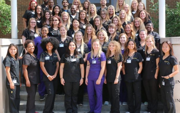 Avila nursing students pose in front of campus building
