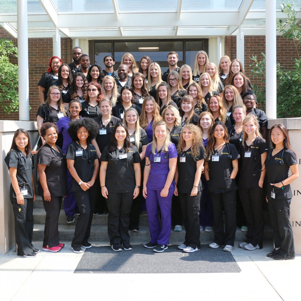 Avila nursing students pose in front of campus building