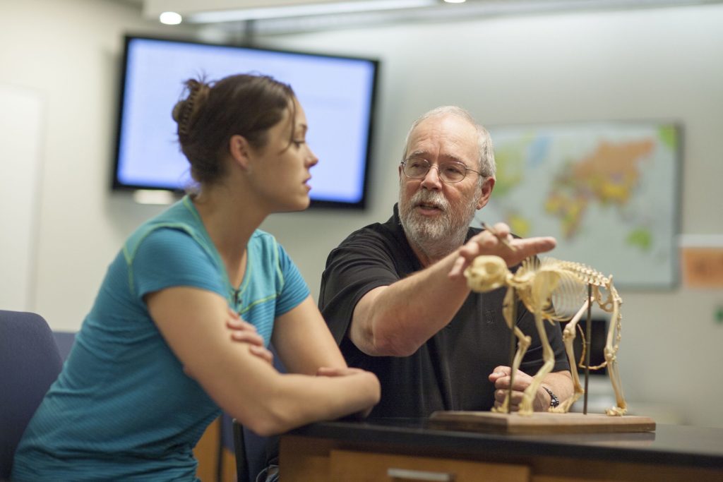 Avila Professor Robert Powell talking with a student