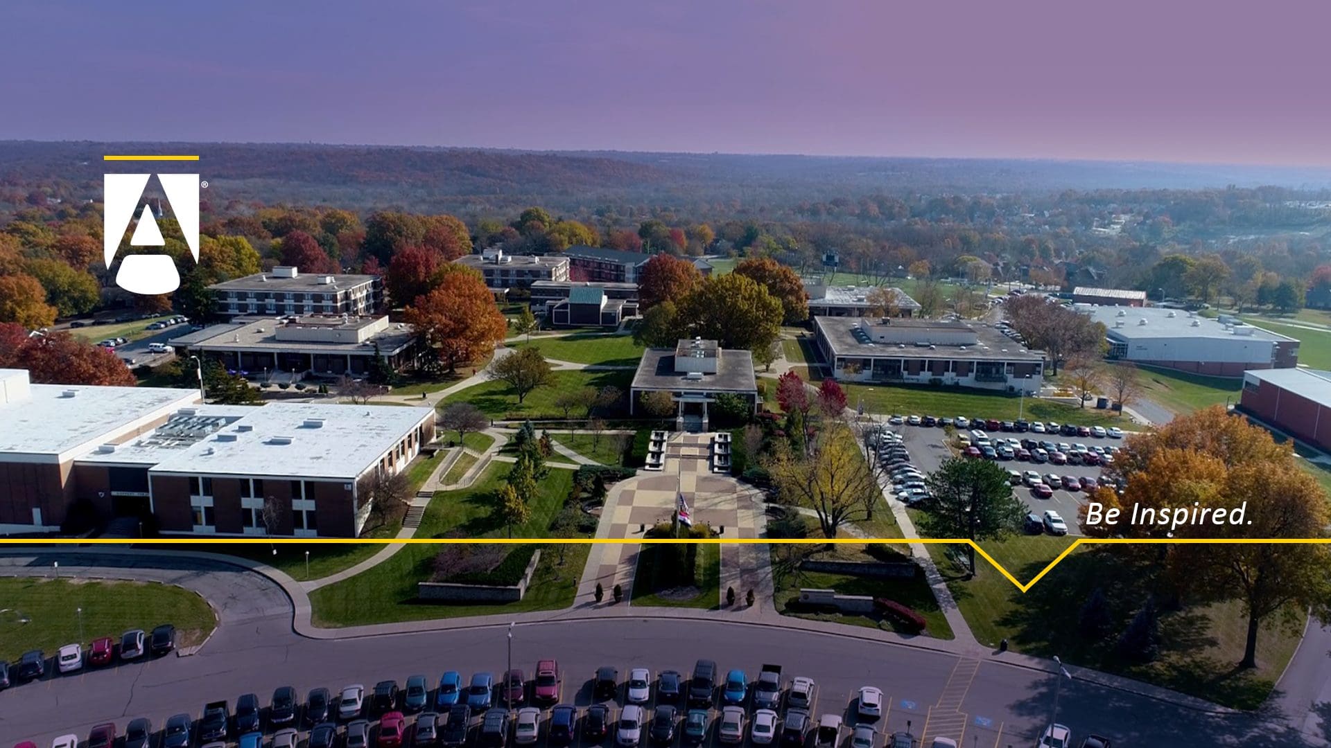 Aerial view of campus looking south with the JHOP Plaza in the foreground. Text says "Be Inspired."