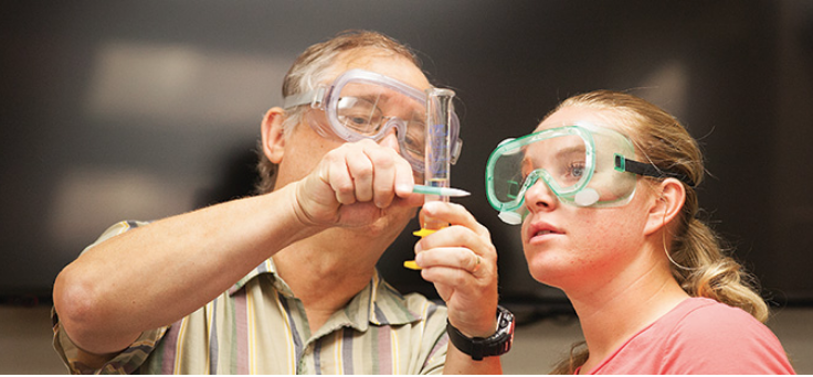 Avila professor and student measuring a liquid in a test tube