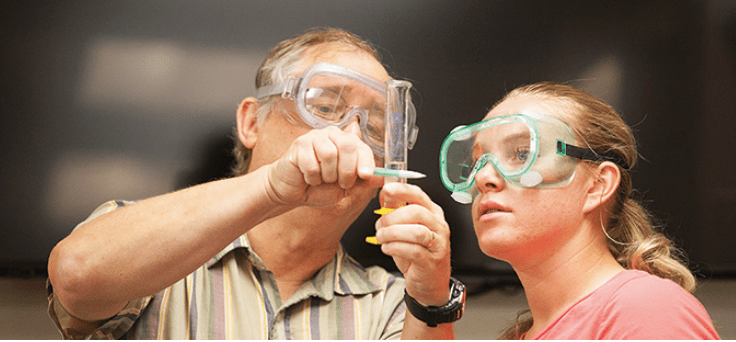 Avila professor and student measuring a liquid in a test tube