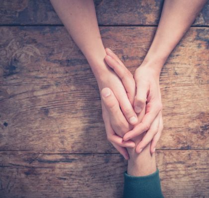 holding hands across a table