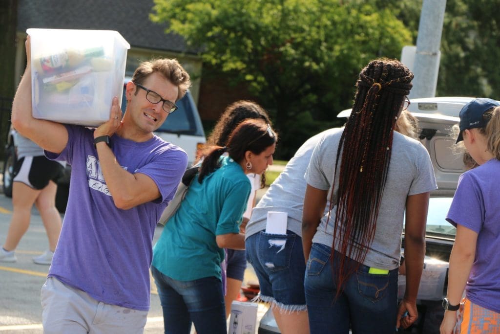 Volunteers helping unload a student's belongings at Move In Day