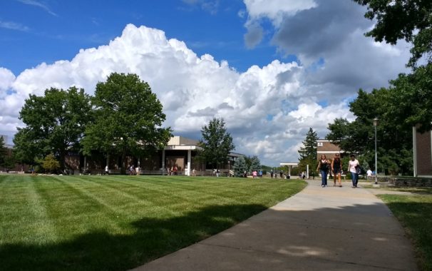 Wide view of the campus Quad with students walking along the sidewalks