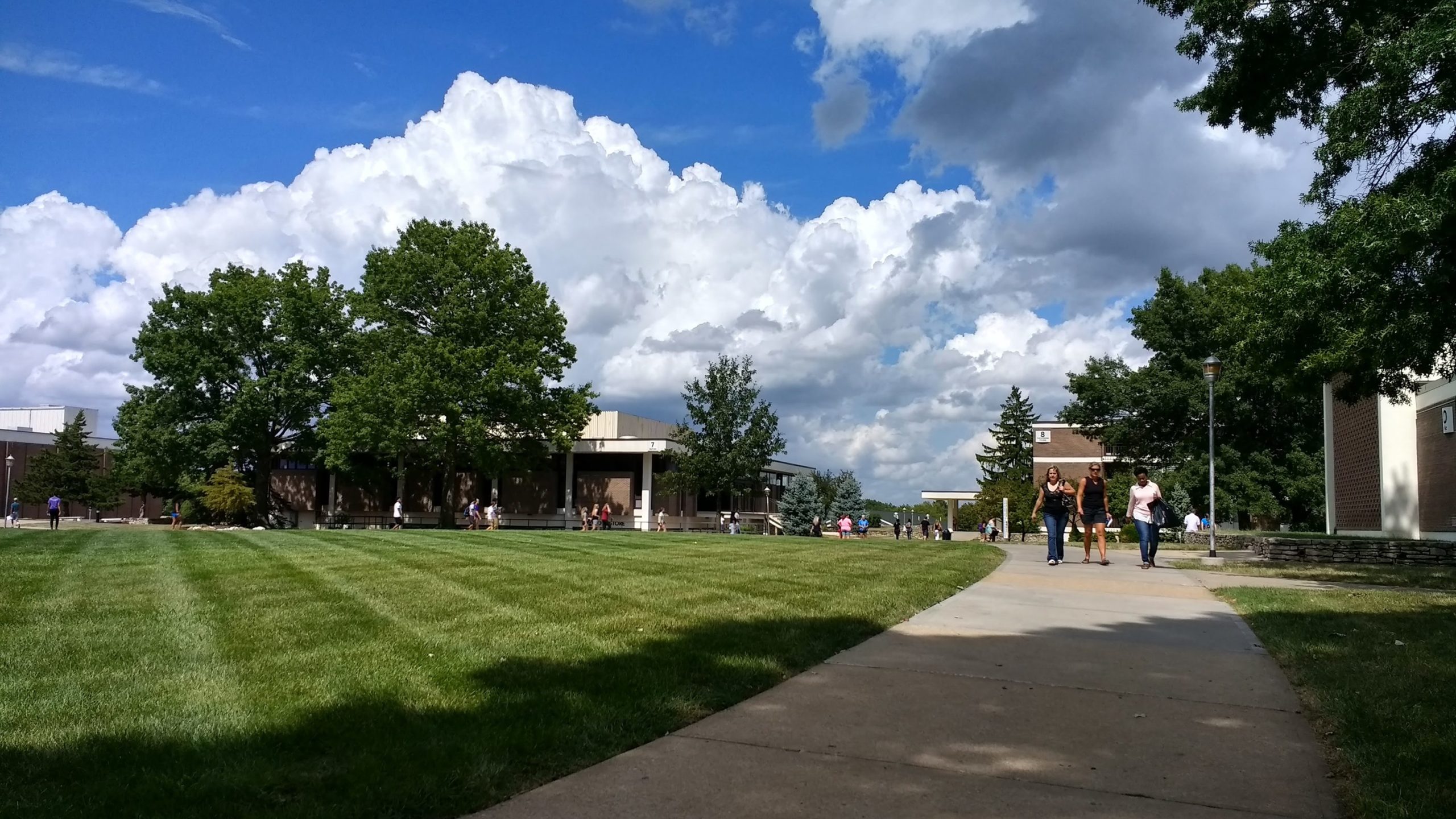 Wide view of the campus Quad with students walking along the sidewalks