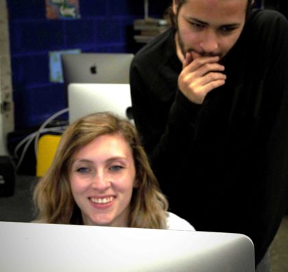 Two theatre students pondering a stage design on a computer screen