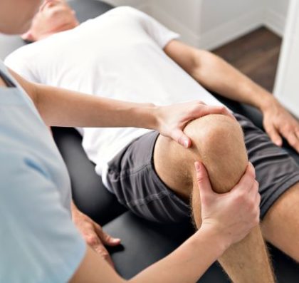 physical therapist with patient manipulating a knee