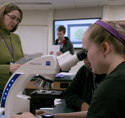 Avila professor working with students in a biology lab