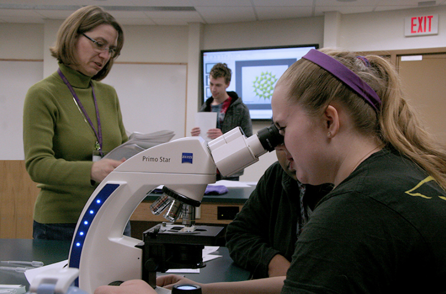 Avila professor working with students in a biology lab