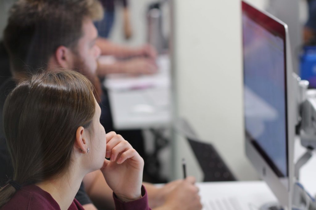 Two students working closely at a computer