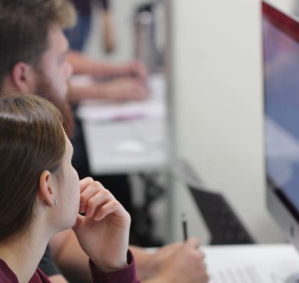 Two students working closely at a computer