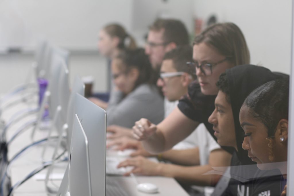 Graphic design professor working over the shoulder of her students