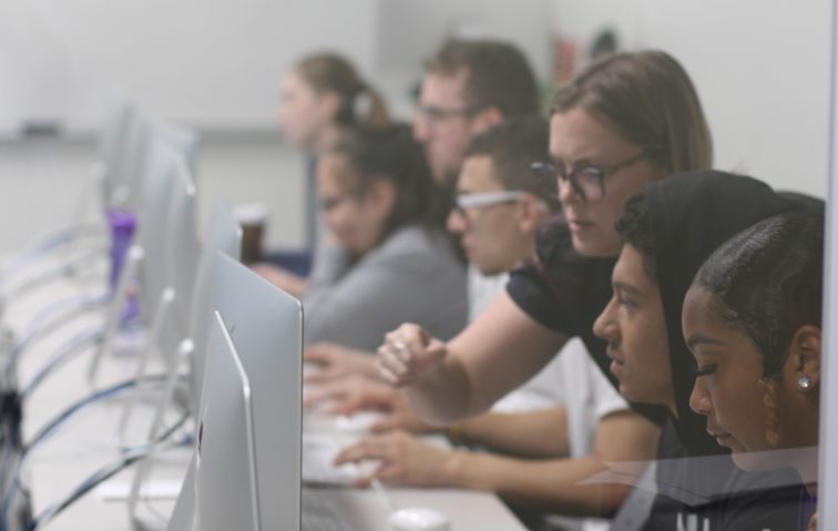 Graphic design professor working over the shoulder of her students