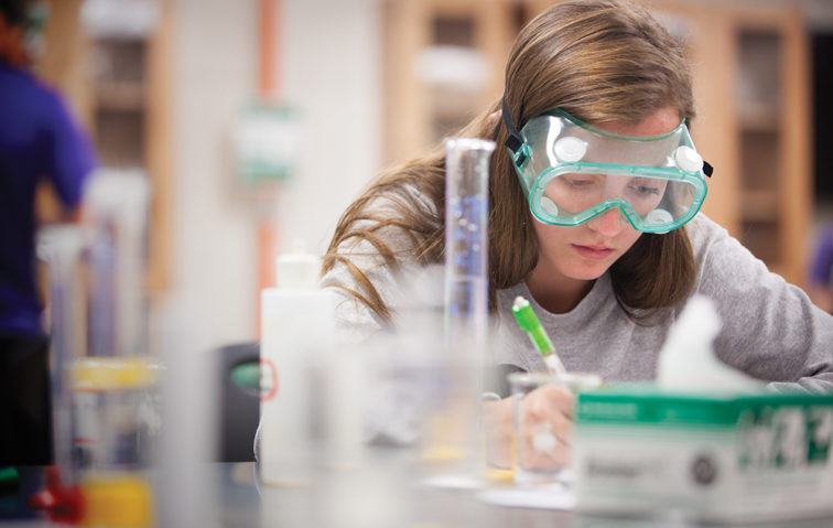 Female student wearing goggles in a lab