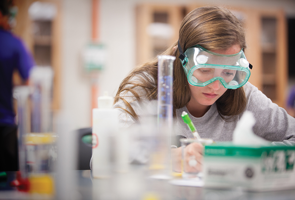 Female student wearing goggles in a lab