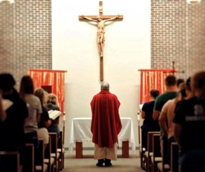 Father Keith Branson beneath the cross inside the Foyle Hall chapel