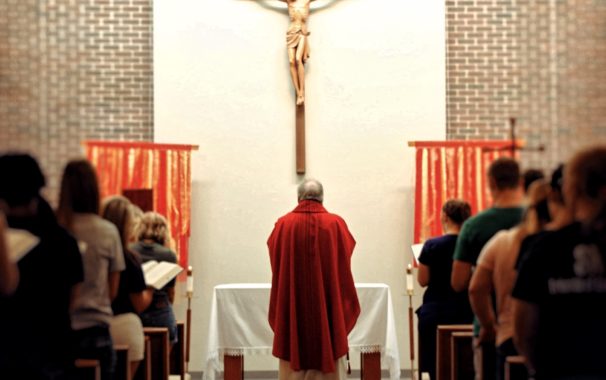 Father Keith Branson beneath the cross inside the Foyle Hall chapel