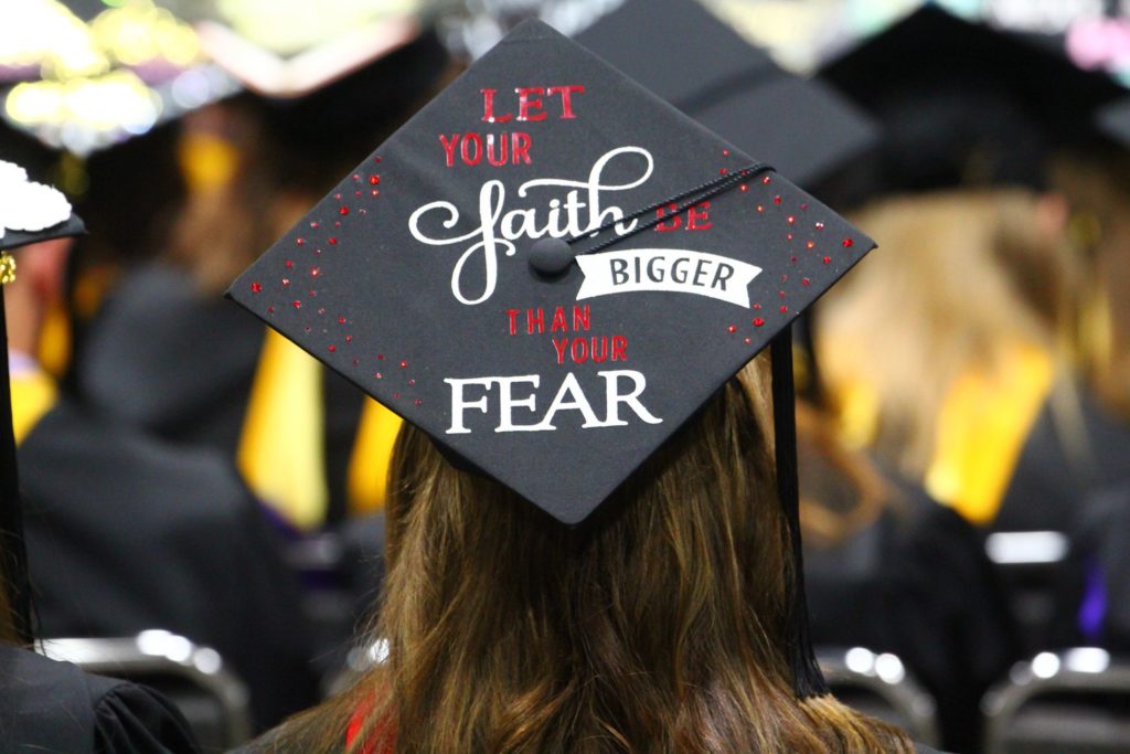 Graduation cap decoration reads, "Let your faith be bigger than your fear."