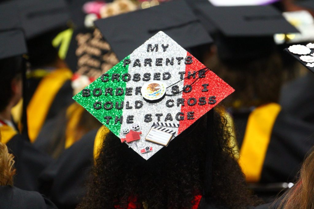 Graduation cap decoration reads, "My parents crossed the border so I could cross the stage."