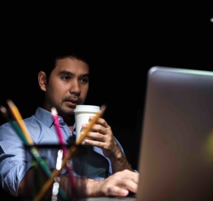 Man works at a laptop at night