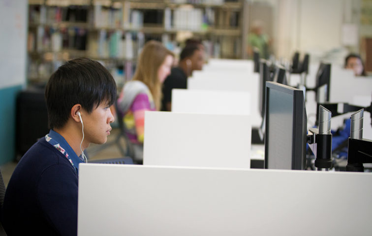 A row of students using the public computers inside the Learning Commons