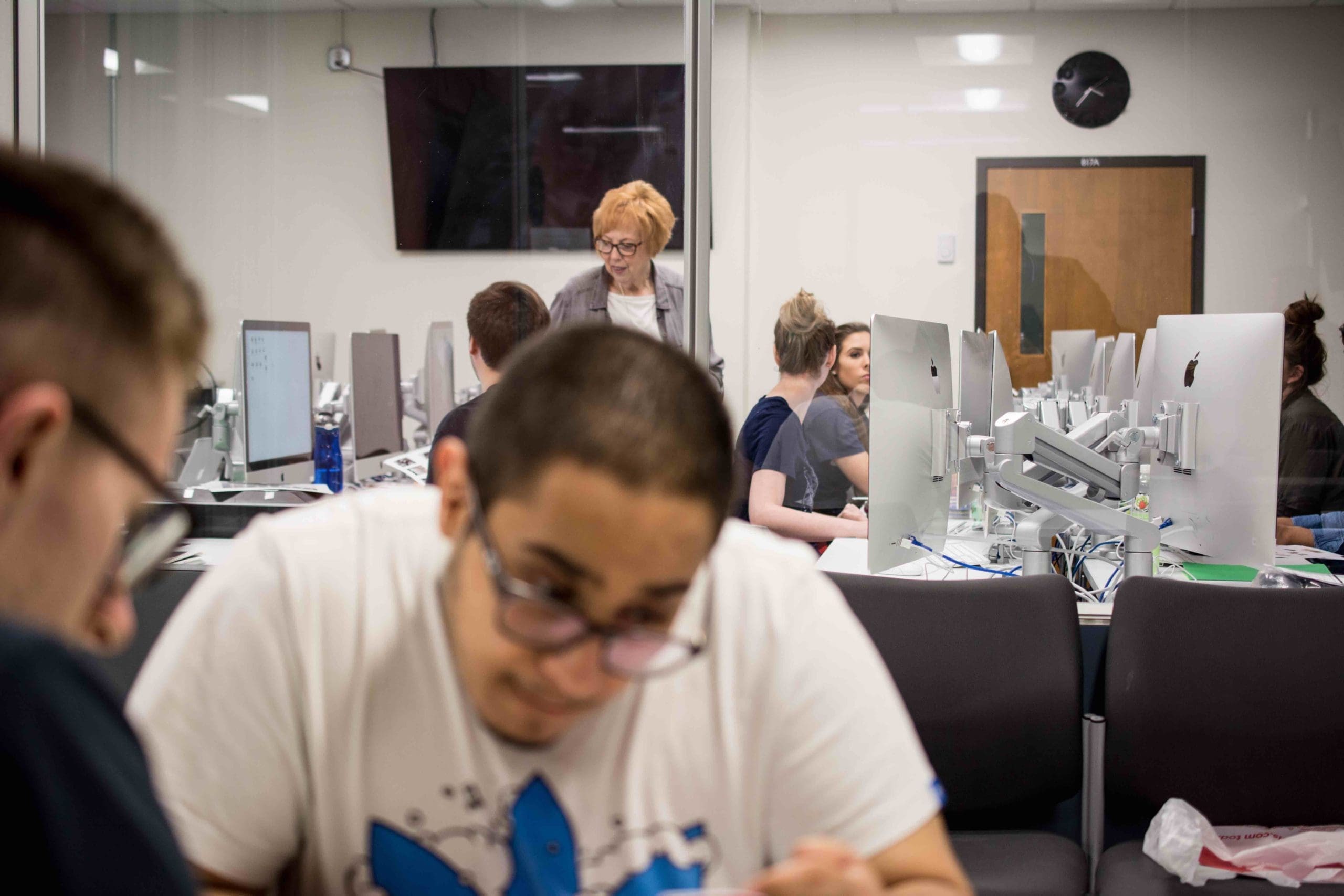 Graphic design students working in small groups in the VisCom mac lab