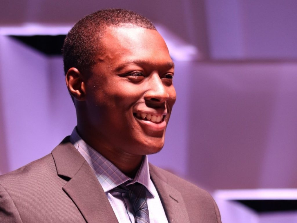 Picture of young man in suit with purple background