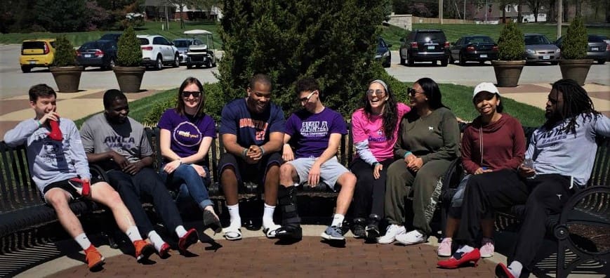 Group of students and faculty sit outside on the JHOP plaza