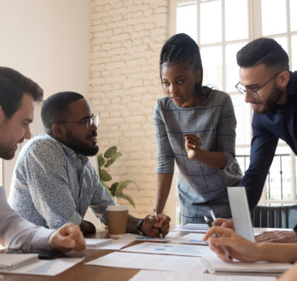 Diverse group of young professionals working around a conference room table