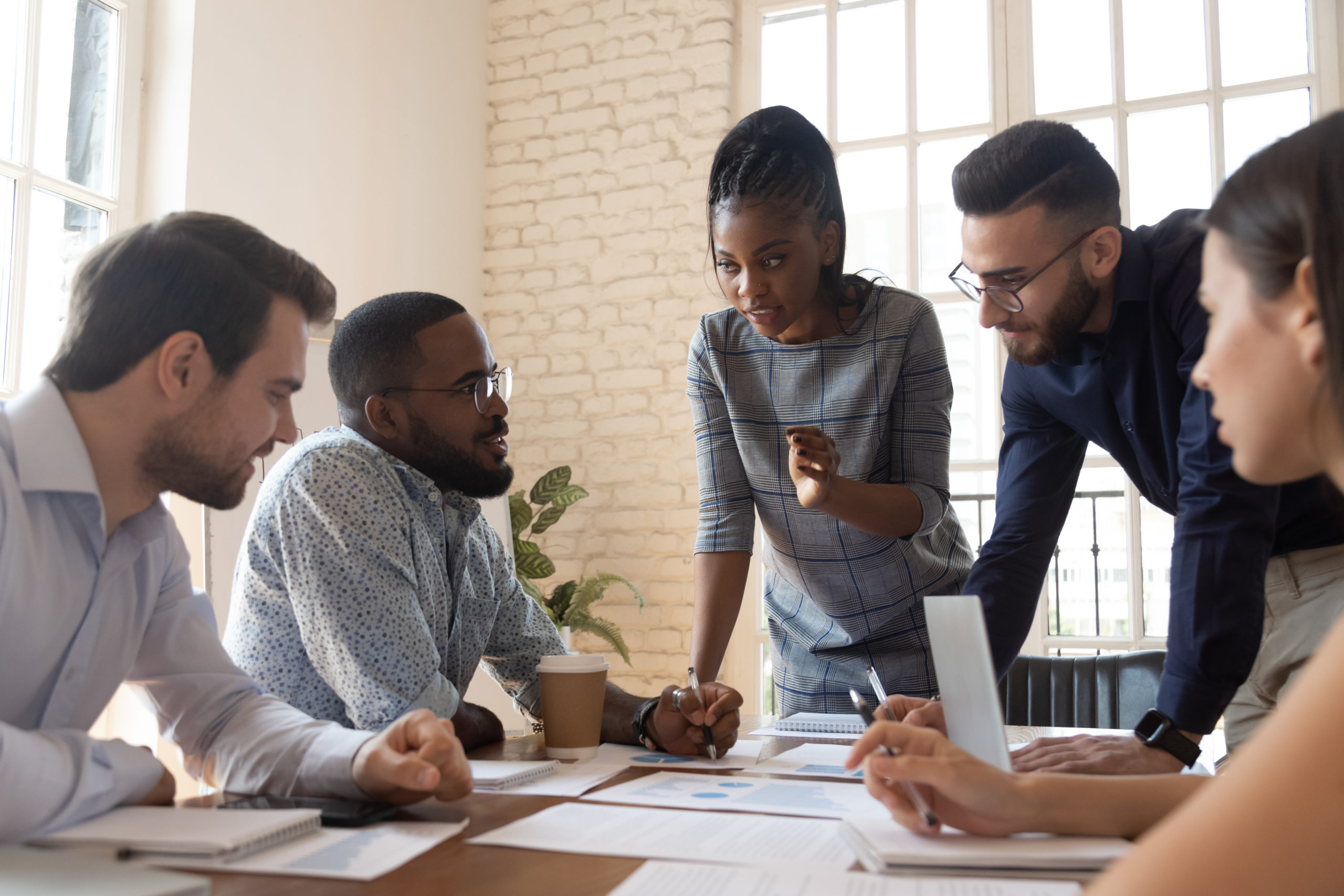 Diverse group of young professionals working around a conference room table