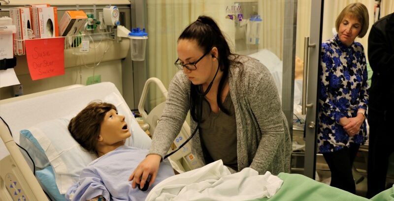 Student attending a "patient" in the nursing simulation