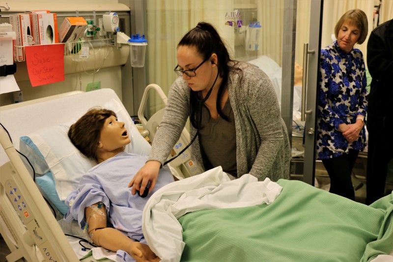 Student attending a "patient" in the nursing simulation