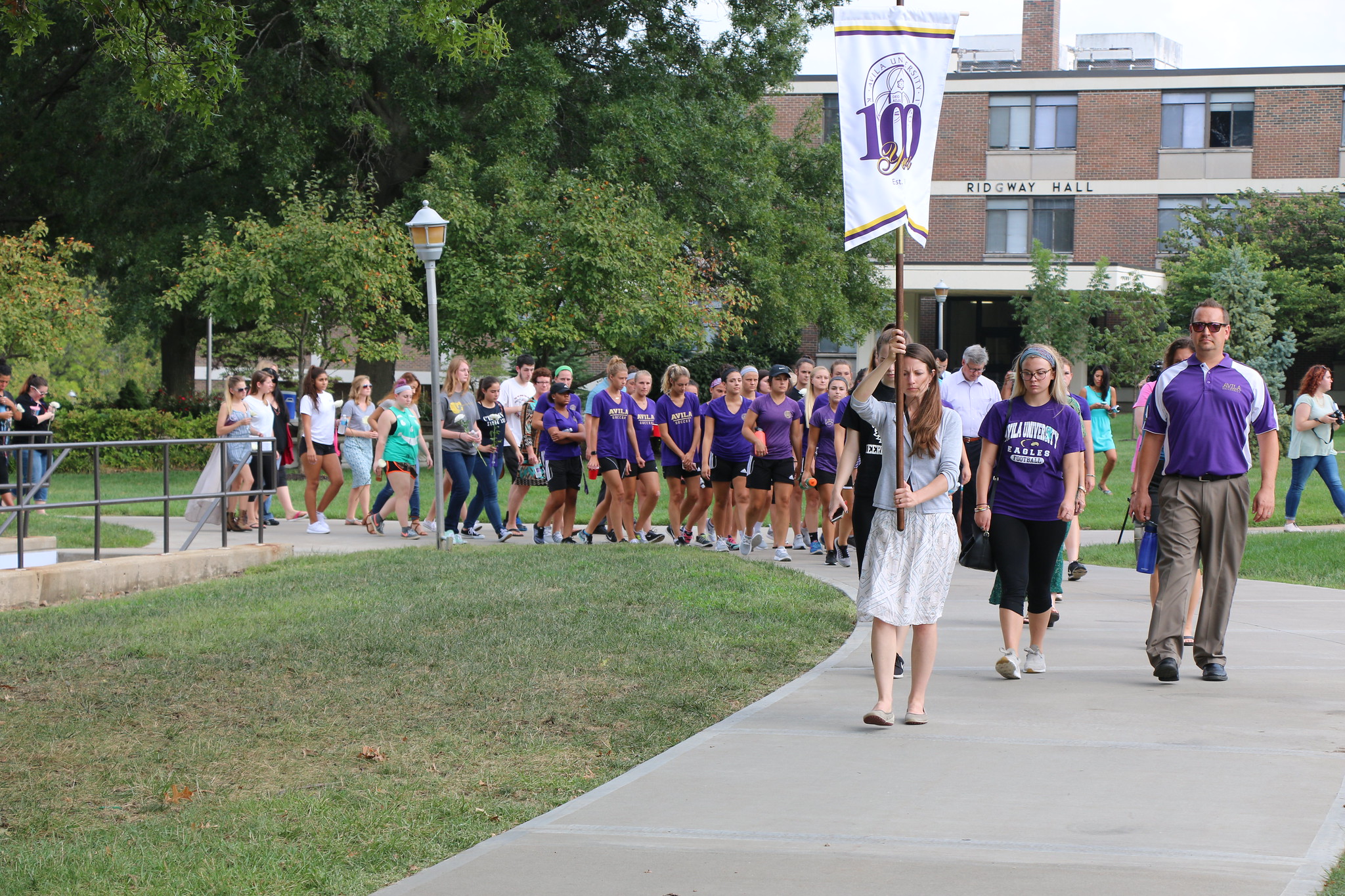 Group of Avila students, faculty and staff walk through campus