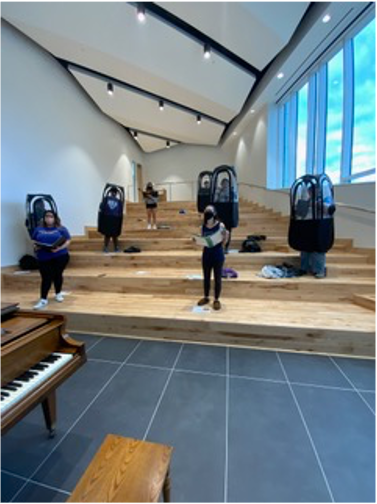 Photo of students posed in choral performance space.