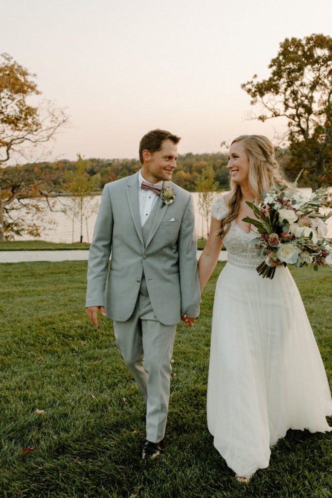 Photo of groom and bride walking in field