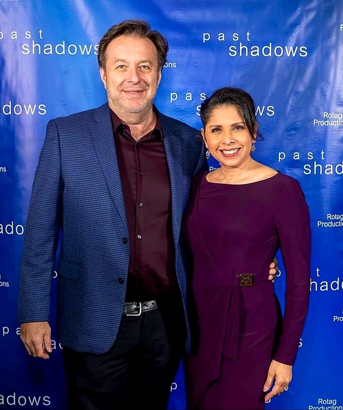 Photo of man and woman in front of a banner