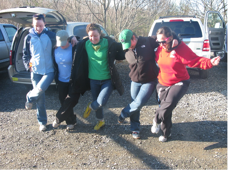 Five students in a dance line, kicking up their heals