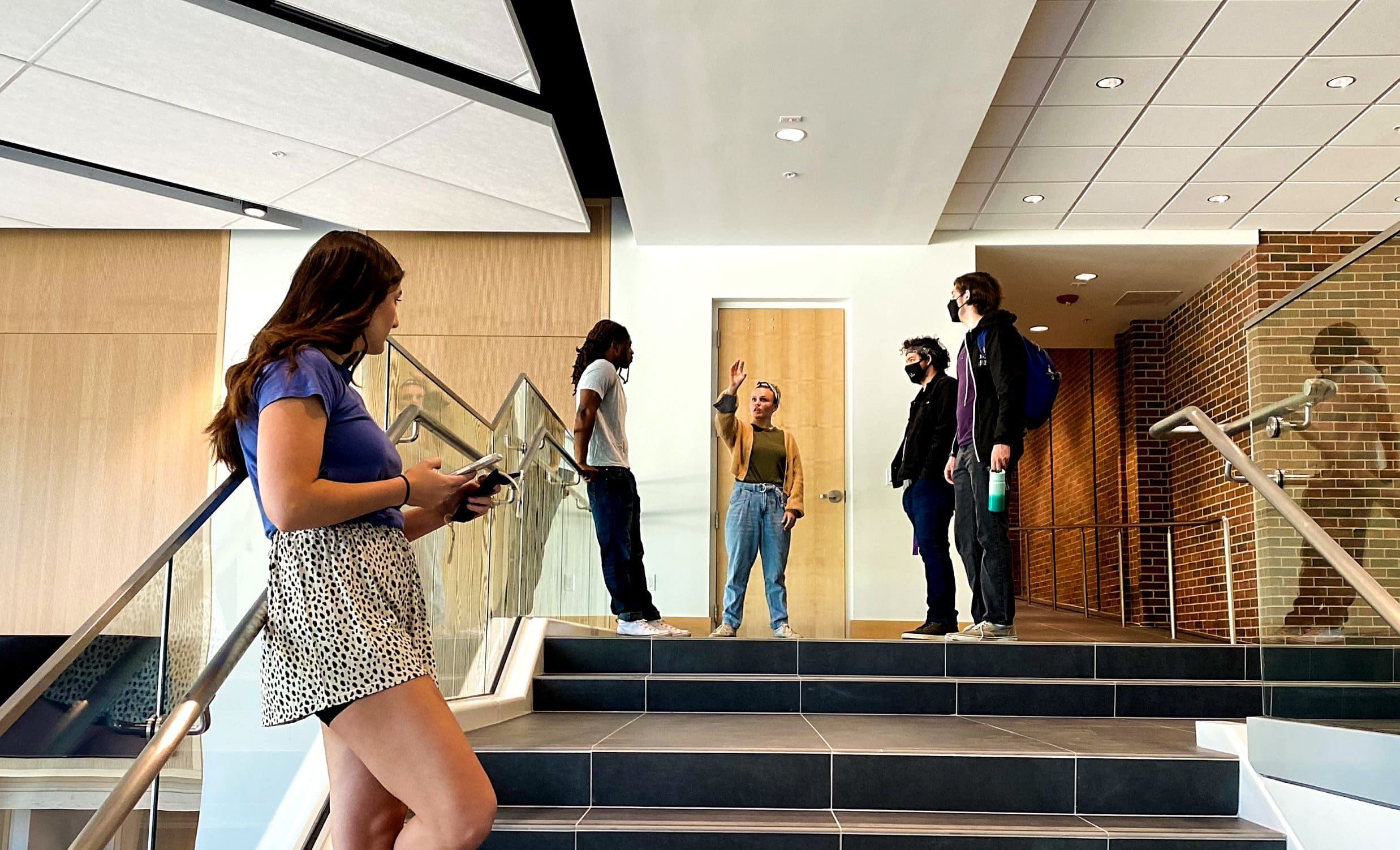 Students in conversation on the stairs of the GPAC grand lobby