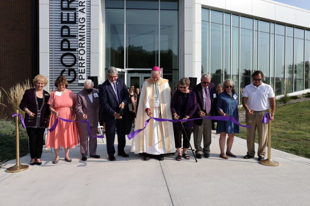 Dignitaries cut the ceremonial purple ribbon signaling the opening of the Goppert Performing Arts Center