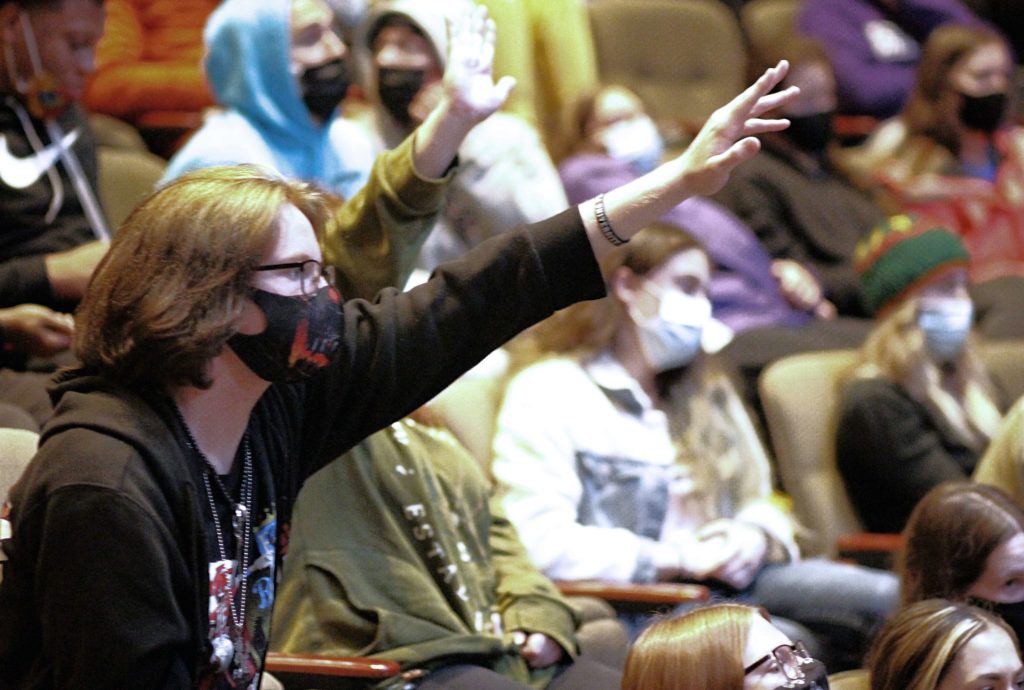 Students raise their hands to answer questions during a lecture inside Goppert Theatre